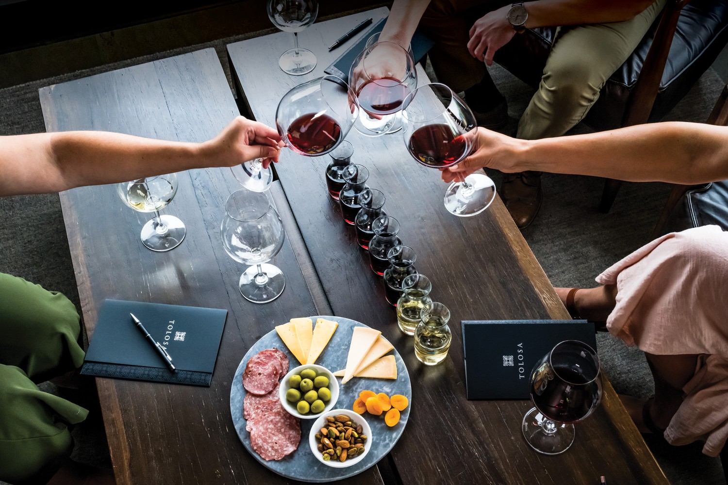 Image of cheese plate and a cheers with wine