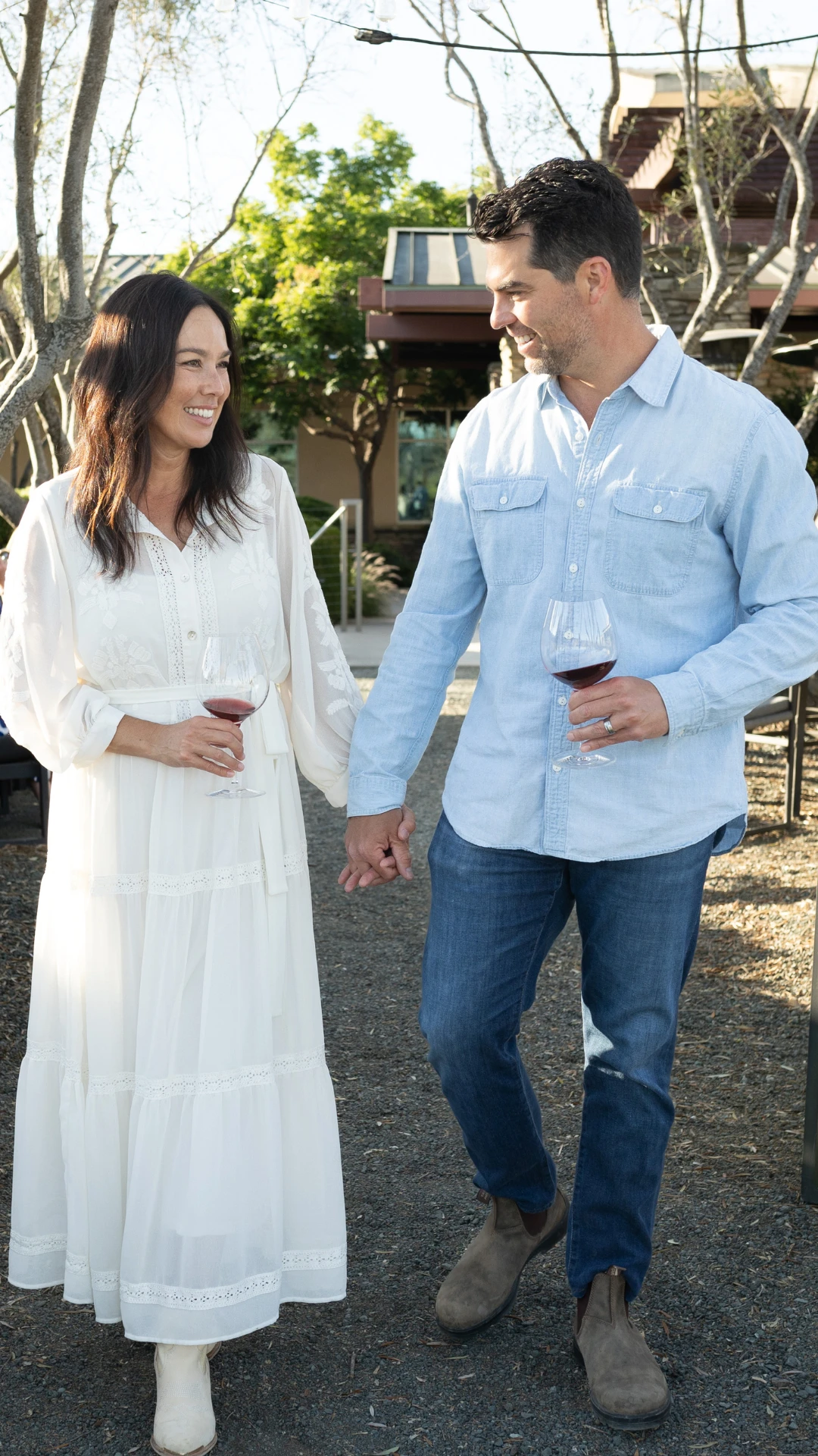 A couple holding hands with glasses of Tolosa wine